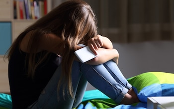 Teenage girl with head in hands