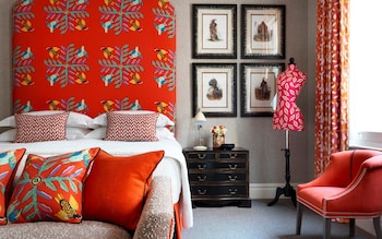 A bedroom with red furnishings and curtains