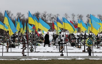 A woman walks among the graves at the Alley of Heroes, where Ukrainian soldiers killed in the war are buried, in Kramatorsk, Donetsk