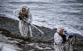 Camouflaged troops from Norway made their way across the pebbled beach