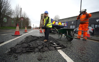 Esther McVey filling in a pothole